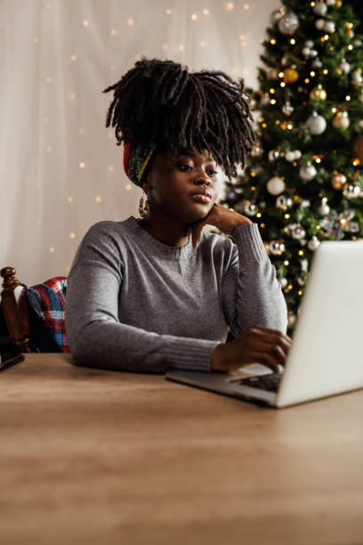 istock Young woman sitting at home office desk and using laptop while working 1455212815