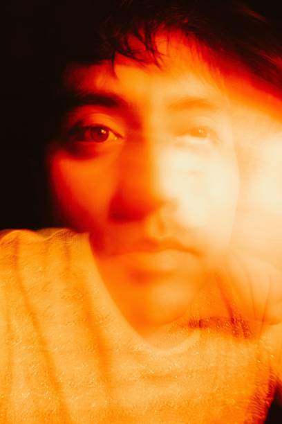 istock Portrait Of Man Amidst Multi Colored Lights with long exposure At Night 1455213268