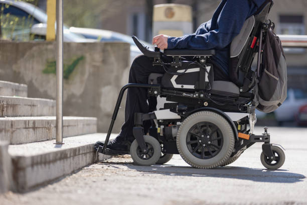 istock Man with disability on wheelchair stopped in front of staircase 1455213430