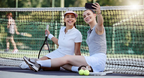 여성, 테니스 코트 또는 전화 셀카에서 피트니스 본딩, 운동 휴식 또는 경기 또는 경쟁 스포츠를 위한 훈련. 행복한 미소, 테니스 선수 친구 또는 소셜 미디어 모바일 기술의 사진 - tennis court sports training tennis net 뉴스 사진 이미지