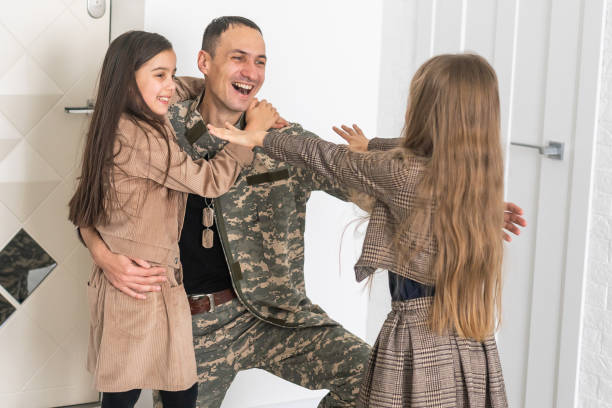 istock Happy military father and two daughters at home. 1455215012
