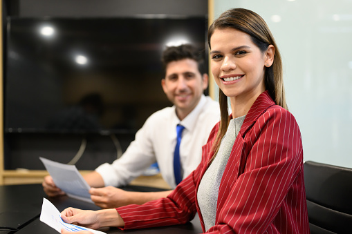 Smiling portrait of happy businessman and businesswoman in office, People meeting and brainstorming together in conference room, Happy working with colleague, Teamwork and partnership concept