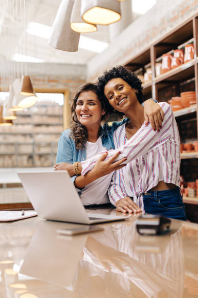 istock Cheerful ceramic shop owners embracing each other in their store 1455217789