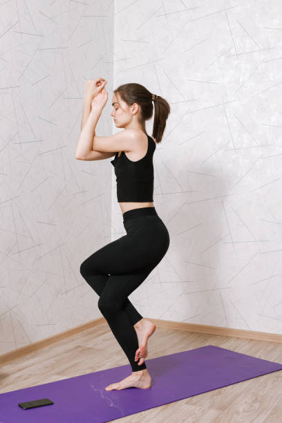 istock Flexible female practicing yoga at home 1455223308