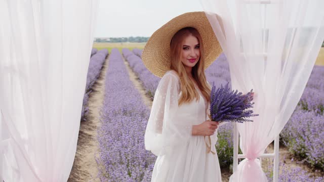 beautiful girl in a hat near the gazebo among lavender flowers