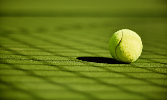 Tennis, sport and fitness with tennis ball on turf with green closeup and texture, sports match and competition. Training, active and ball on tennis court, outdoor tournament and competitive game.