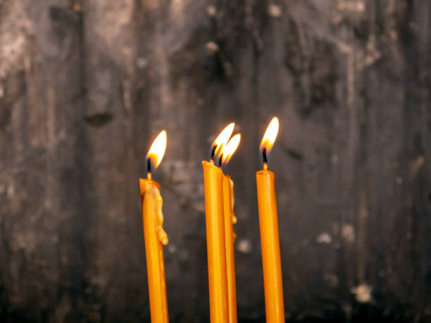istock Yellow religious candles flame on Iron table, special place in Orthodox chirch 1455226471