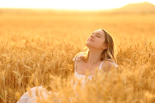 Woman breathing in a golden wheat field