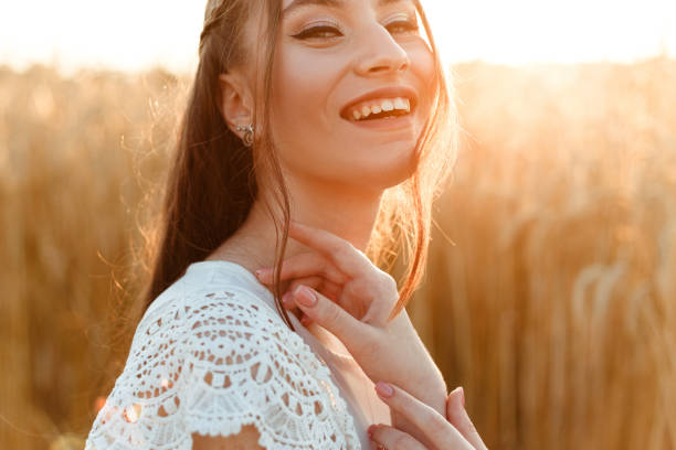 istock Smiling young woman in field  at sunset 1455227145