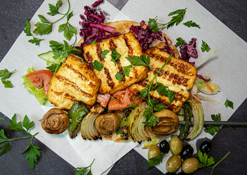 Over head shot of grilled Halloumi with olives and salad