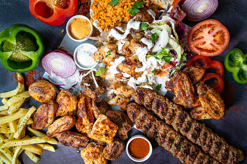 Over head shot of chicken, lamb kebab style take away food with salad and pitta