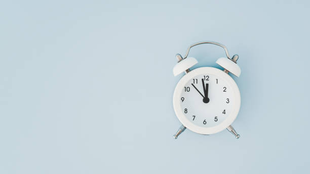 istock top view of white analog alarm clock on grunge blue background including copy space 1455228296