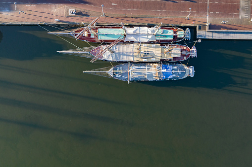 Old sailing ships on the quay in Kampen city at the river IJssel seen from above