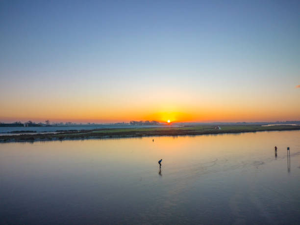 istock Ice skating on a lake in The Netherlands during a beautiful winter sunset 1455229620