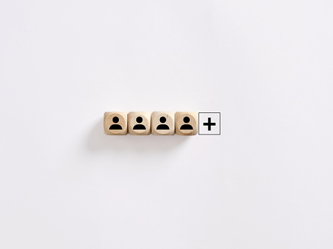 Creating a successful team. Vacant job position. Search for new employees. Hiring, staffing and employment. Personnel management. Leadership position. Wooden cubes with employee symbols and plus sign.