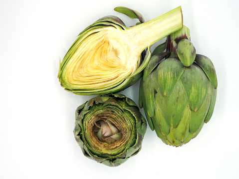 Artichoke flower edible bud and its longitudinal and transverse cut isolated on white background.