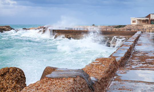 Coastal landscape with stone fortifications and breaking waves