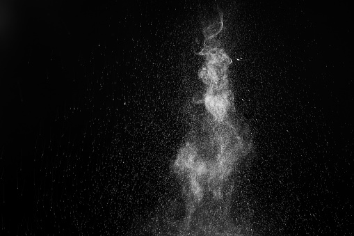 A jet of hot steam with splashes. The movement of hot steam with water droplets is highlighted on a black background to overlay your photos