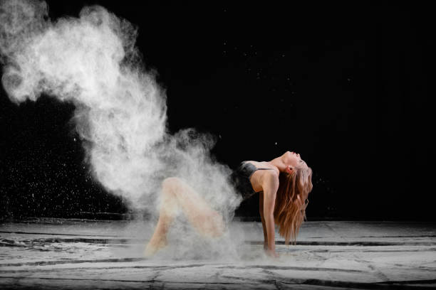 young slim woman with spread flour on the air - motion art naked studio shot imagens e fotografias de stock