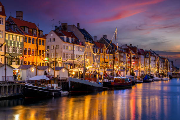 Beautiful winter sunset view of the popular Nyhavn area at Copenhagen Beautiful winter sunset view of the popular Nyhavn area at Copenhagen, Denmark, decorated for Christmas copenhagen stock pictures, royalty-free photos & images