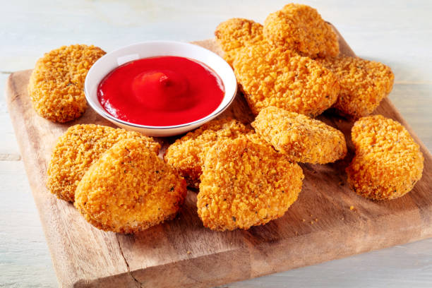 istock Chicken nuggets with bbq sauce on a wooden board 1455239370
