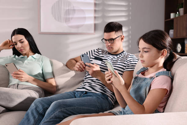 istock Internet addiction. Family with different gadgets on sofa at home 1455239550