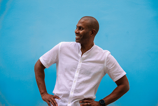 A joyful man standing with a blue background