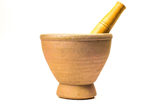 Mortar and Pestle isolated on white background.mortar is a tool for finely grinding herbs in Asian cuisine.handmade earthenware mortar.Old earthenware mortar that has been used for a long time.