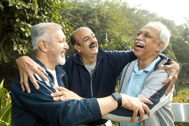 istock Old male friends laughing at park 1455243826