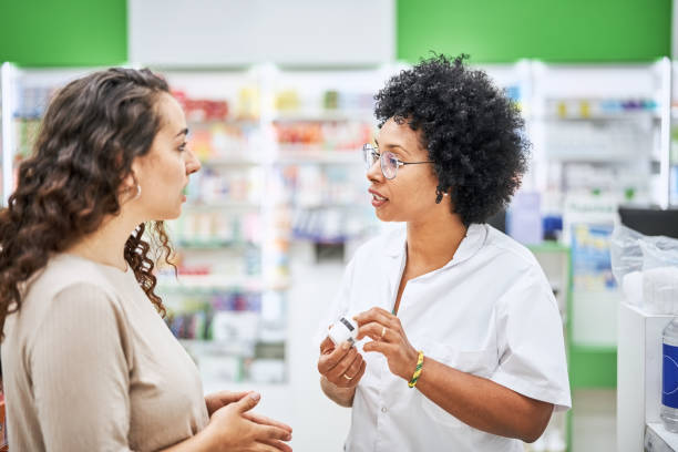 istock Woman pharmacist explaining medication to female customer in pharmacy 1455244412