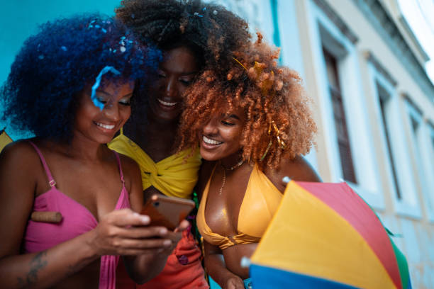 istock Afro people using smartphone at street carnaval 1455245200