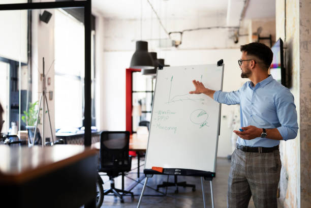 istock Young happy man presenting business plan. 1455245509