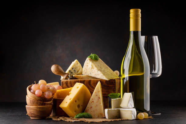 Various cheese on board and white wine Various cheese on board and white wine. Over dark background with copy space wine italian culture wine bottle bottle stock pictures, royalty-free photos & images