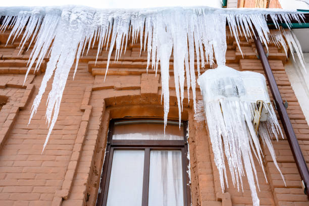 primo piano dei ghiaccioli sul tetto. - icicle hanging snow moving down foto e immagini stock