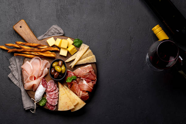 Antipasto board with various meat and cheese snacks Antipasto board with various meat and cheese snacks. Flat lay with copy space prosciutto brie stock pictures, royalty-free photos & images
