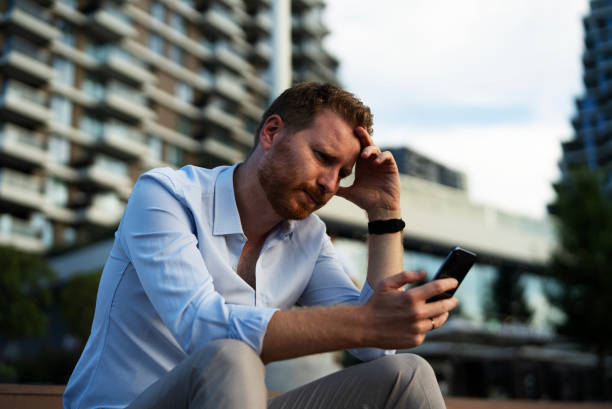 istock Businessmen using the phone while sitting on the stairs. 1455247921
