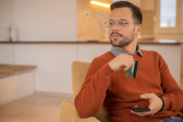 istock Man using his credit card to shop online 1455248918