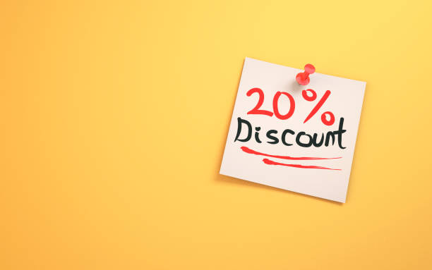 istock 20 % Discount Written on Note Paper Sitting on a Yellow Background 1455250120