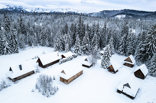 Winter landscape with frozen river and snowy mountains, drone view.