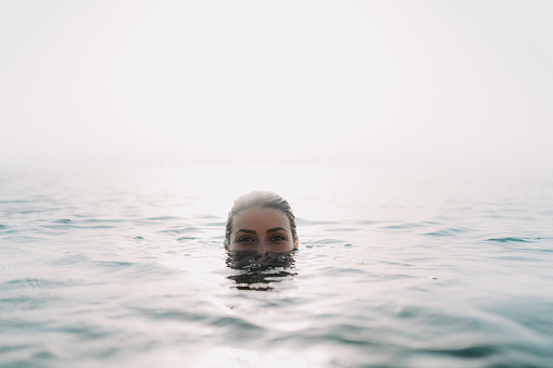 Photo of a young woman relaxing and cooling off in the sea on a hot summer afternoon