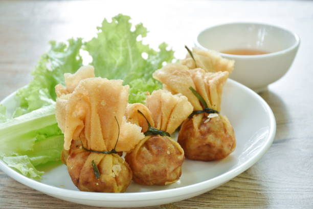 istock Kratong Thong Thai food made from fried mashed pork stuffed in dumpling flour with lettuce dipping sweet sauce 1455252424
