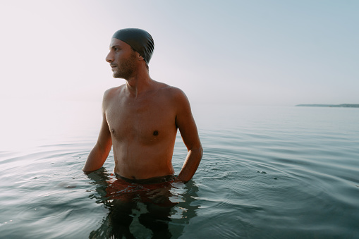 Photo of a young man getting ready for some serious swimming in the sea