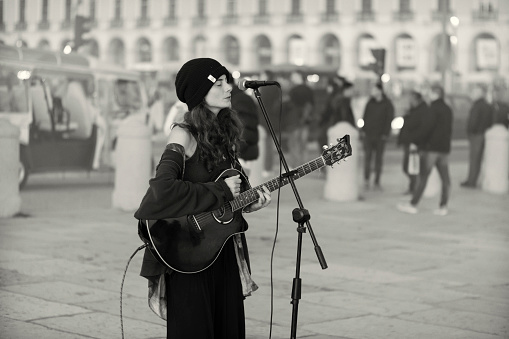 Lisbon, Portugal - December 17, 2022: A street musician performs at the Praça do Comércio square in Lisbon downtown.