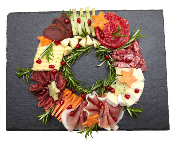 istock Appetizers boards with assorted cheese, meat, grape and nuts. Charcuterie and cheese platter. Top view on white background. Christmas wreath 1455259549