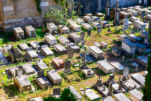 Pisa, Italy – August 22, 2020: Pisa, Toscana Italy - 22.08.2020: The historical cemetery of Camposanto Monumentale photographed from above with many graves covered with stone slabs