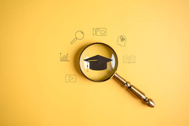 istock E-learning online class, magnifier focus to degree graduation cap icon, watching video on internet, webinar online, education on internet, e-learning, learning online with webinar, education concept. 1455260929