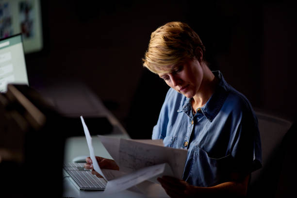istock Businesswoman Working Late In Office With Face Illuminated By Computer Screen 1455261008