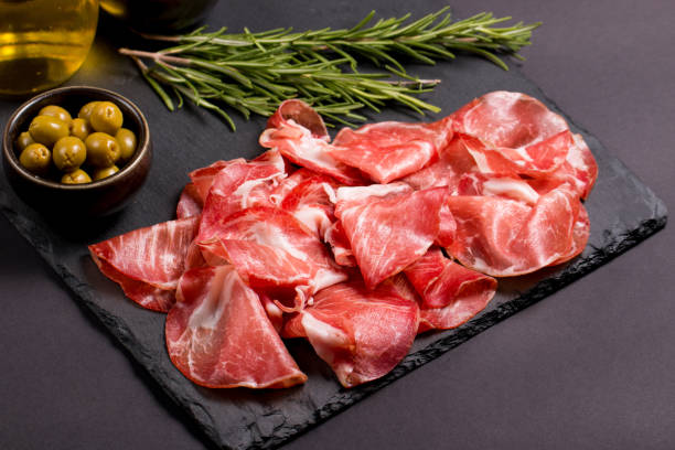 italian slices of coppa, capocollo, capicollo, bresaola or cured ham with rosemary. raw food. - pancetta imagens e fotografias de stock