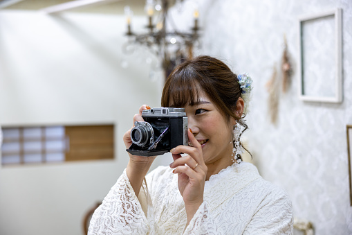 Woman in white lace kimono taking pictures