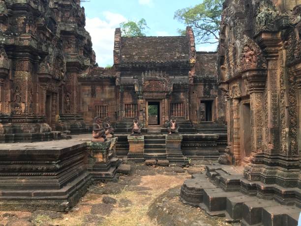 sítio histórico no camboja, banteay srei, a cor rosa do calcário e as elaboradas esculturas decorativas de muitas divindades femininas que enfeitam suas paredes - srei - fotografias e filmes do acervo
